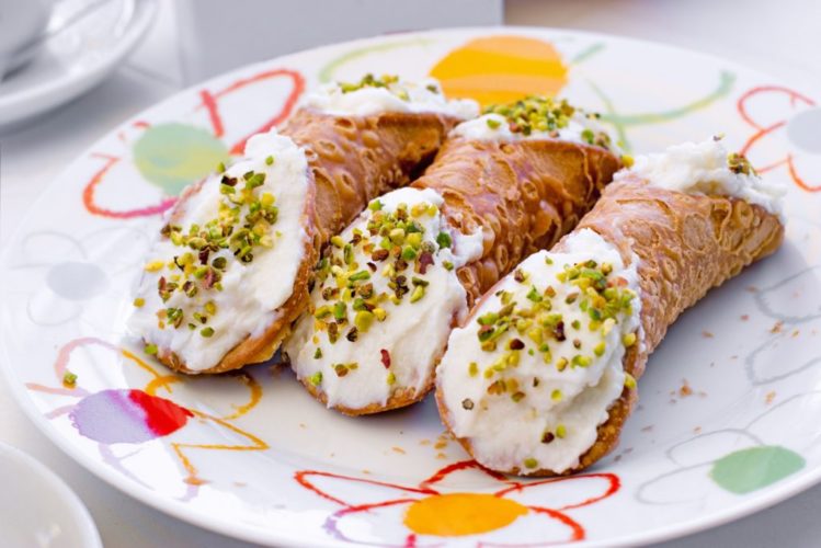 Cannoli filled with whipped cream, delicious dessert on plate